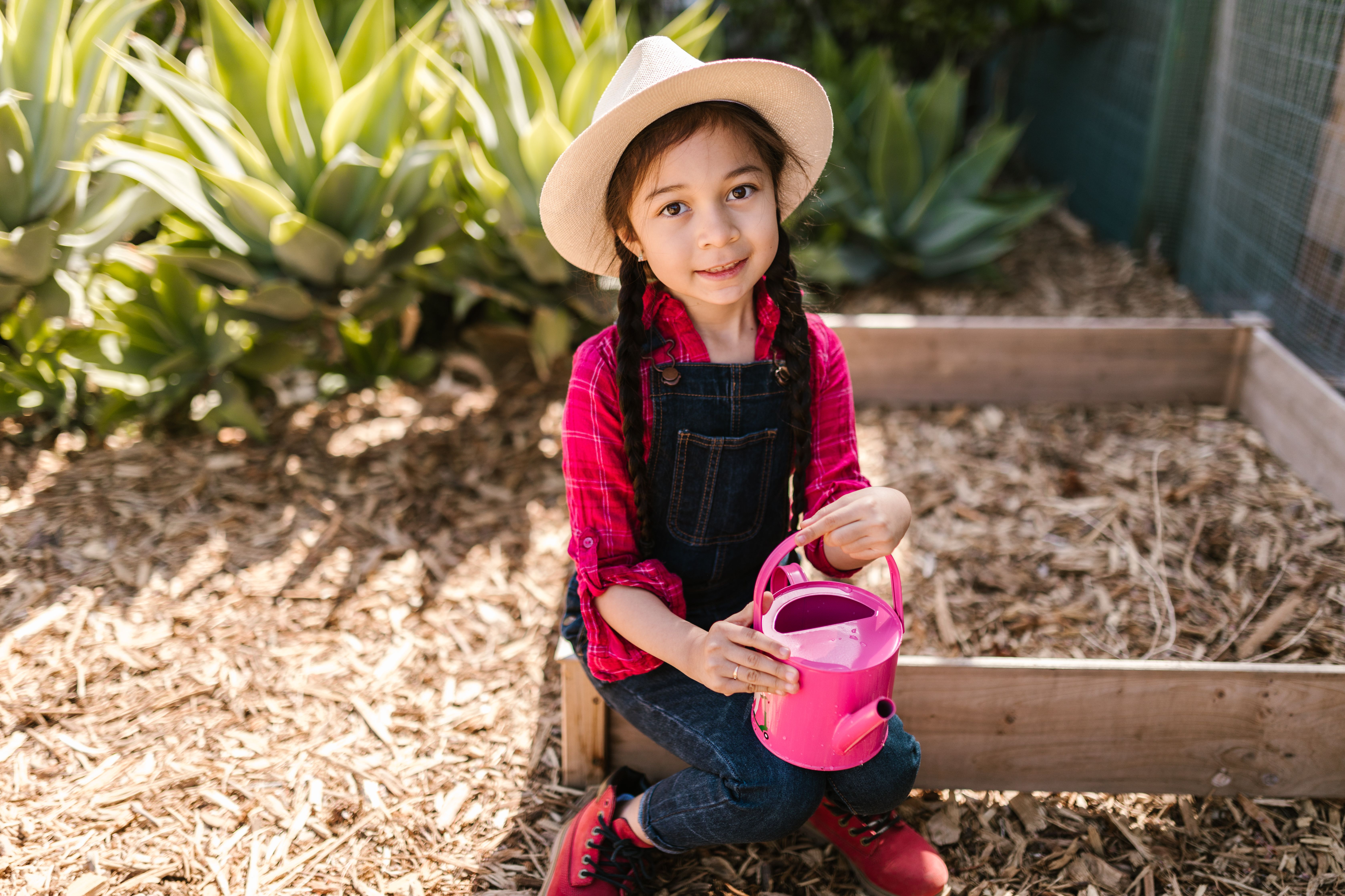 Girl planting in a school garden as part of an outdoor and nature enrichment activity